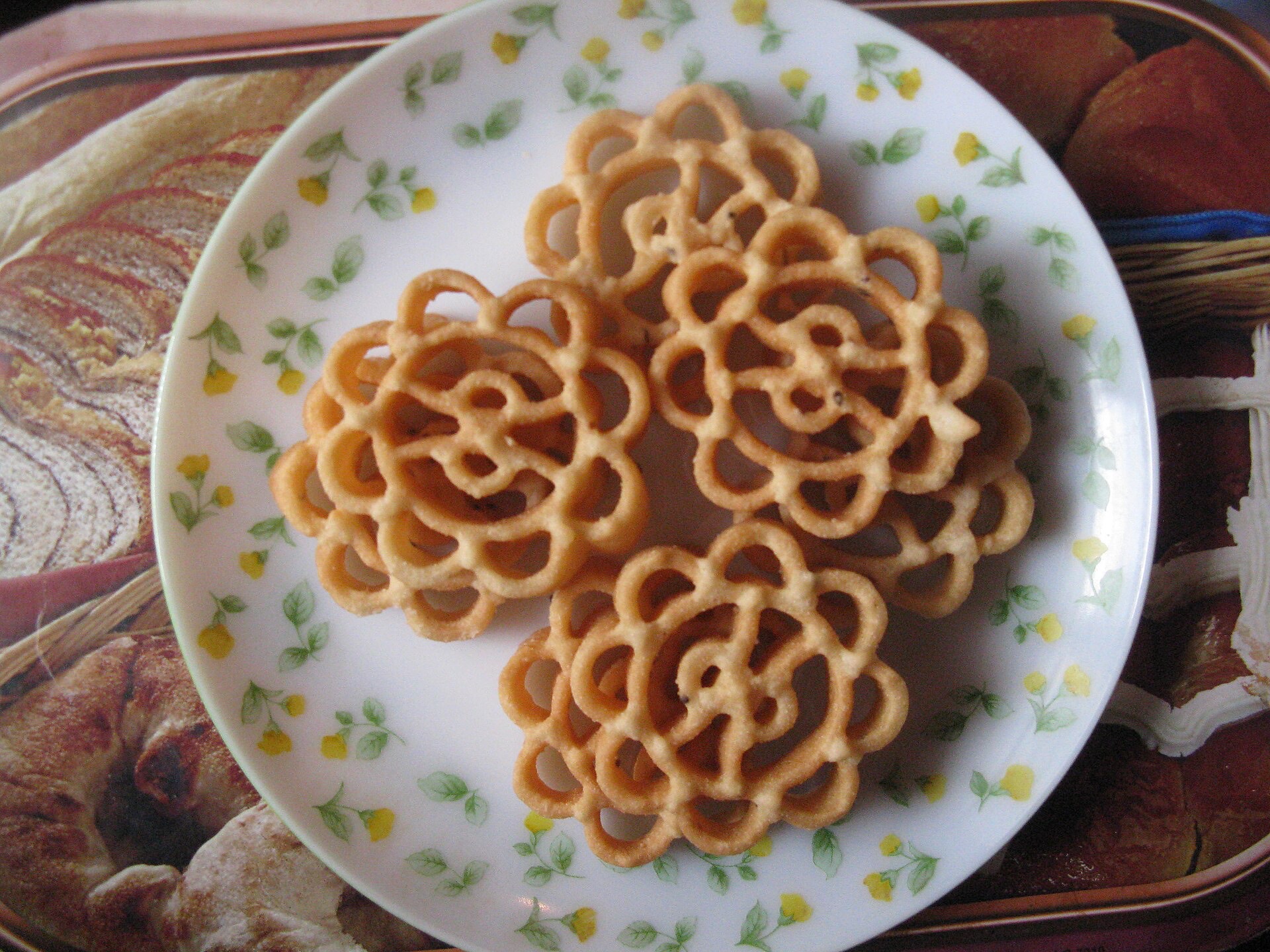Achappam - crisp golden rose-shaped Kerala cookies stacked on a plate.