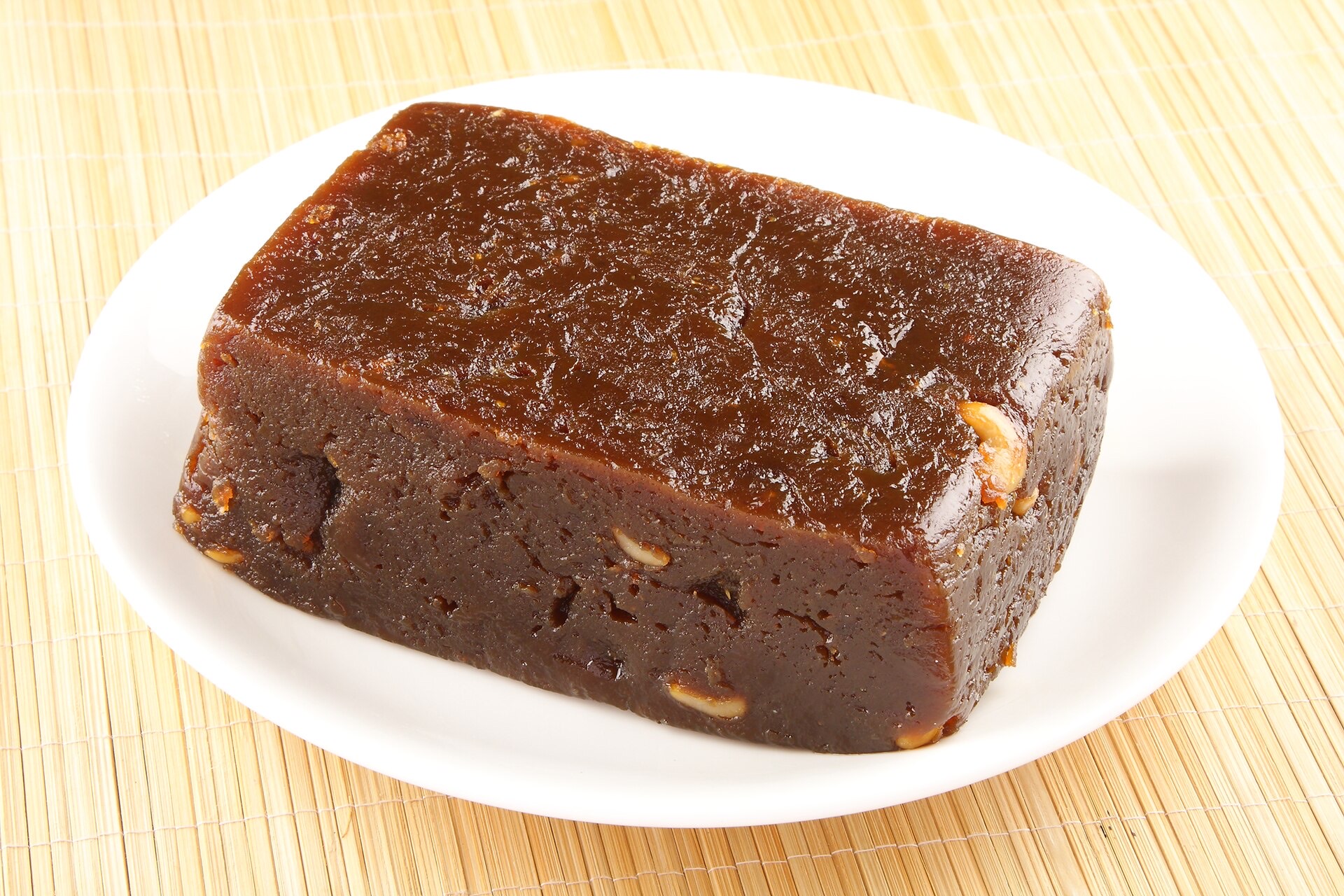 Glossy slabs of Kozhikodan halwa in deep red and black, cut into cubes.