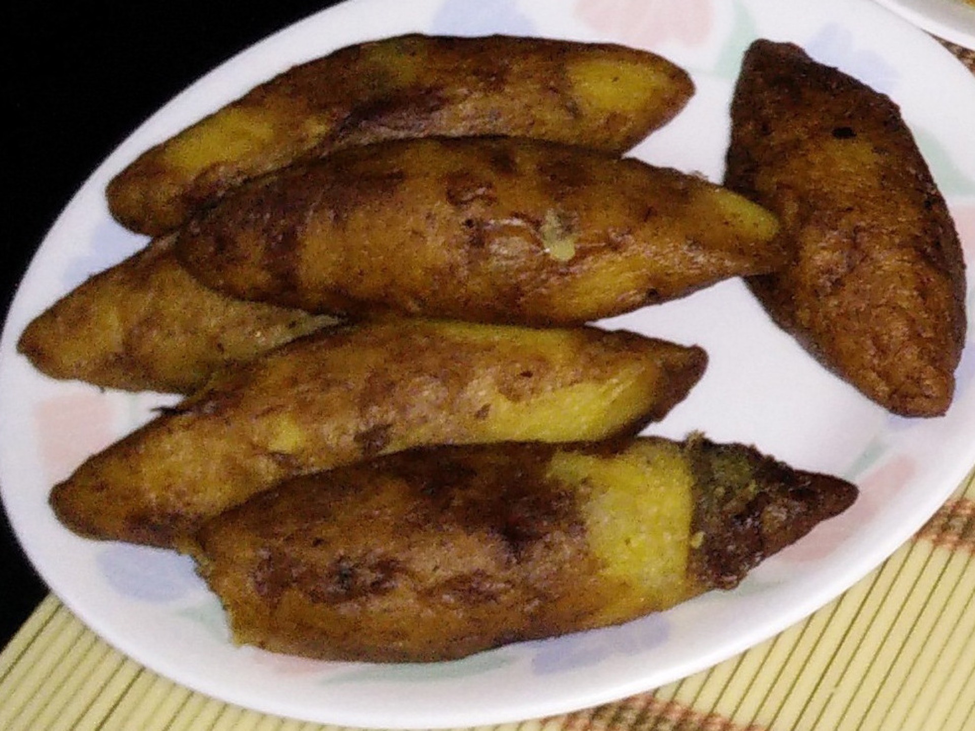 Unnakaya - golden spindle-shaped Malabar stuffed plantain sweets, one halved to show the coconut filling.